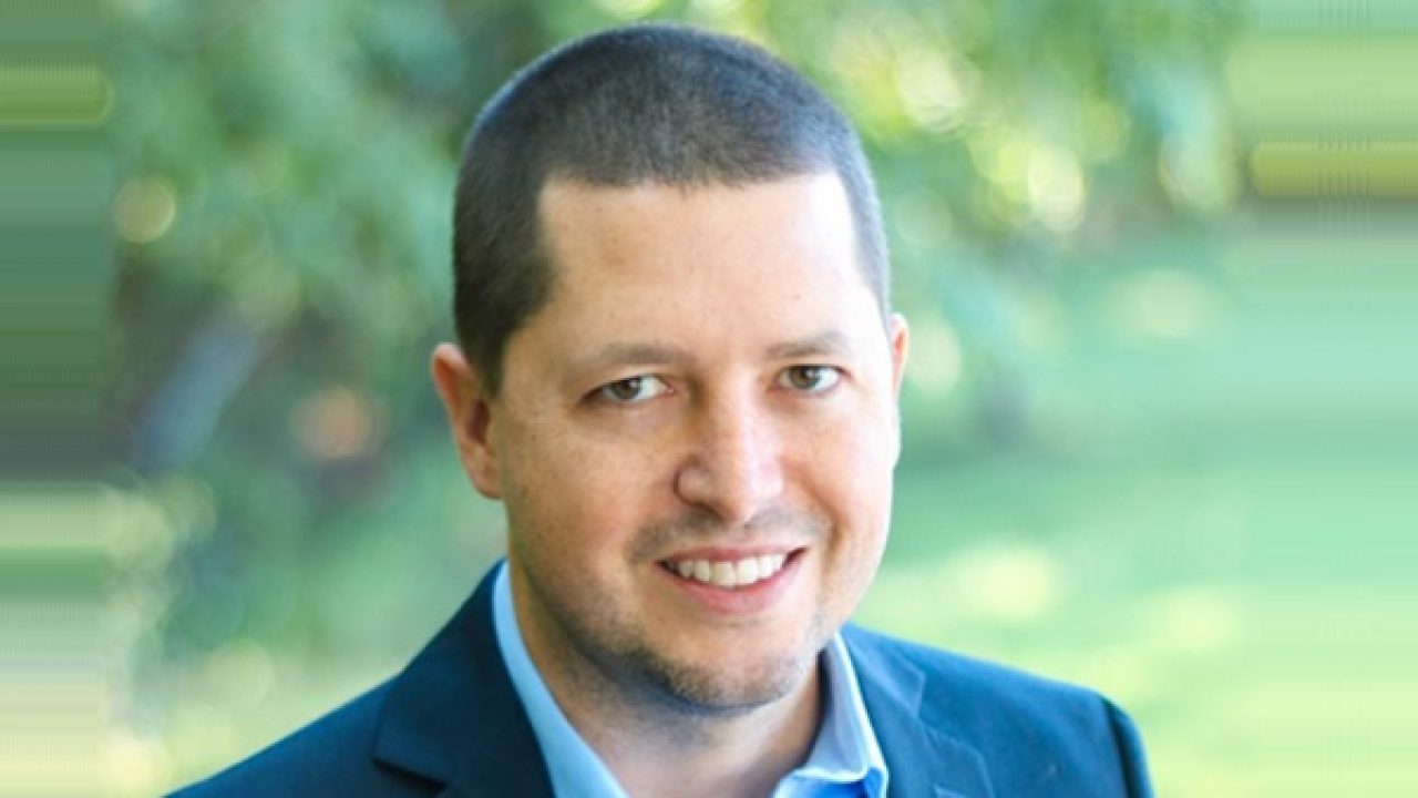 A man in a suit is smiling for the camera.