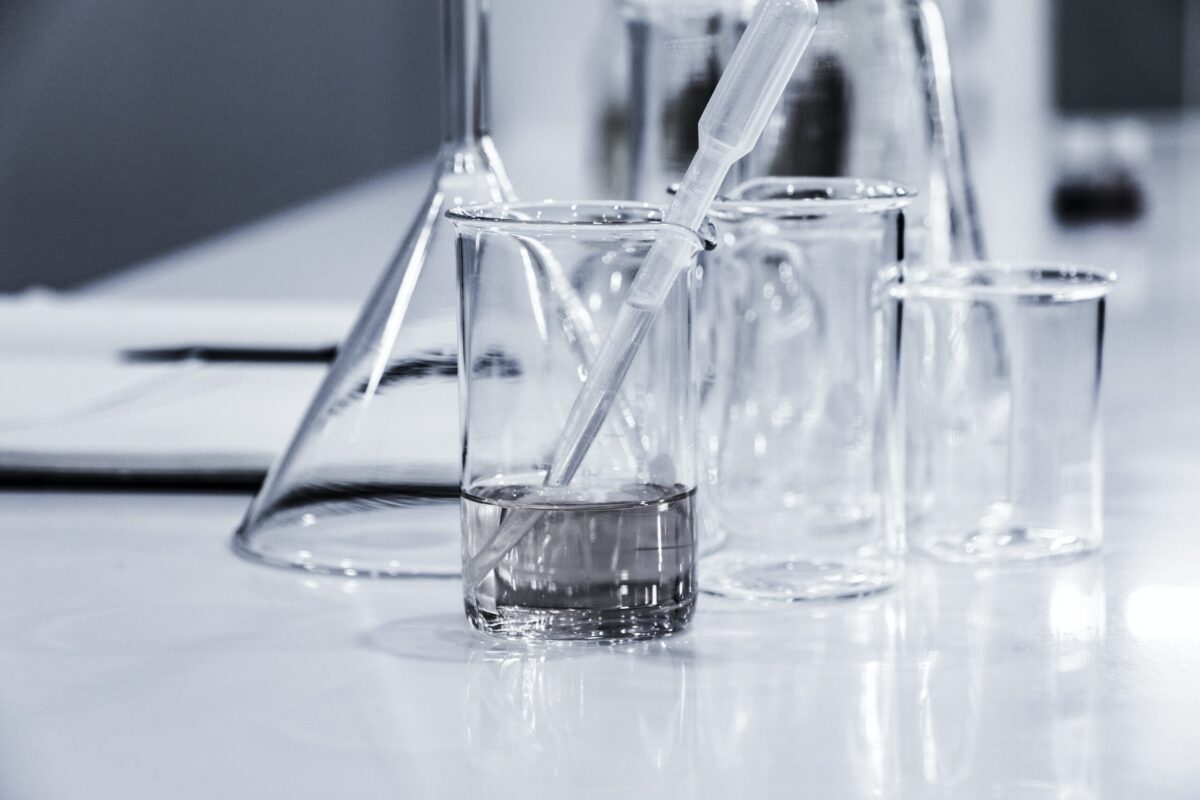 A glass of liquid in a glass beaker on a table.