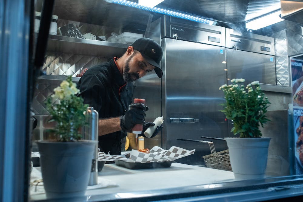 A man is preparing food in a food truck.