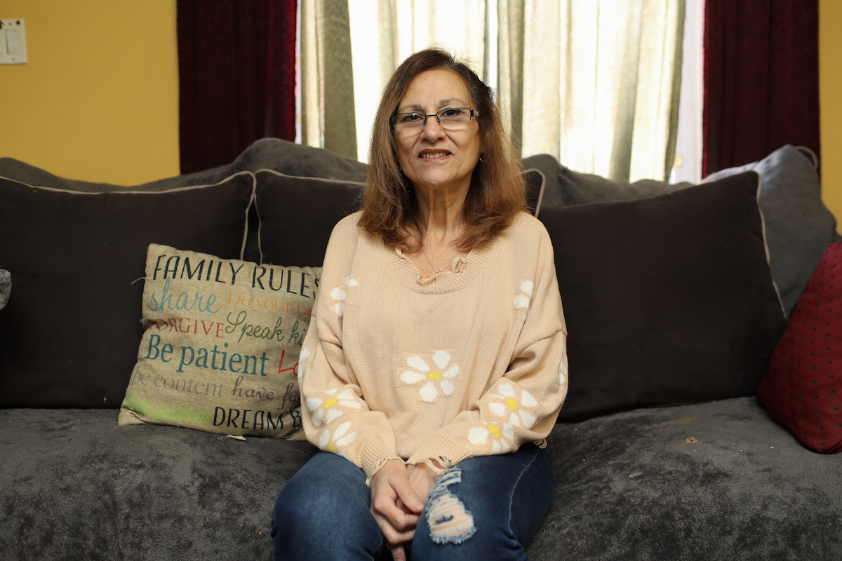 A woman in glasses sitting on a couch.