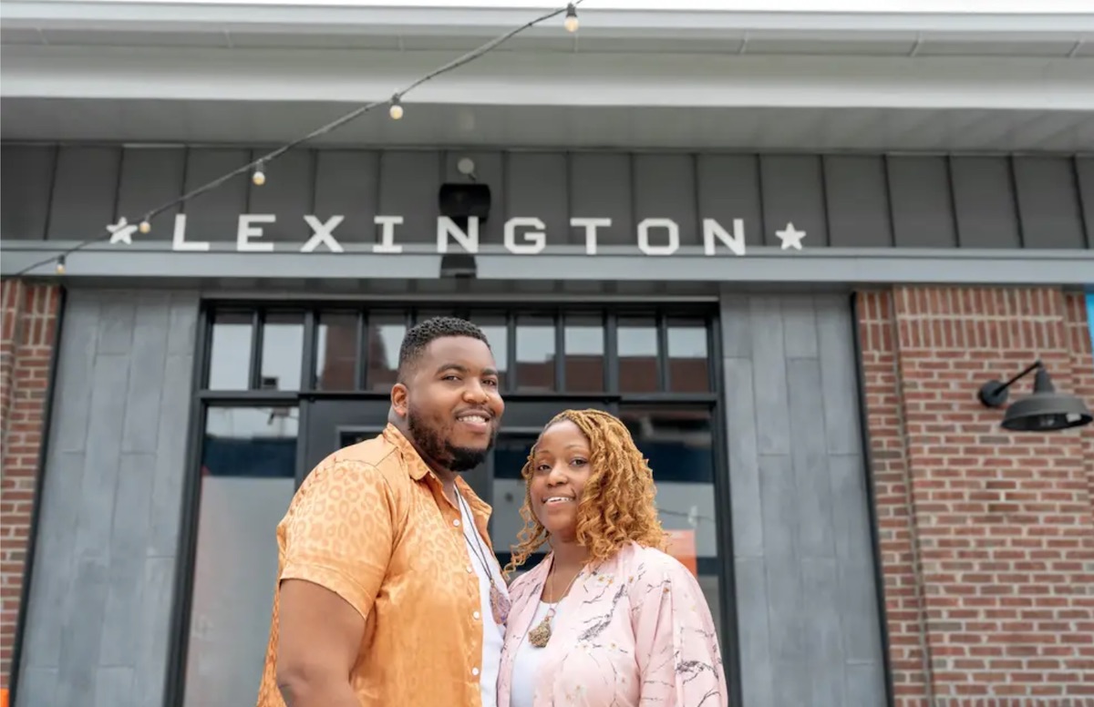 Tyron and April Harper in front of grey and brown Lexington Market entrance.