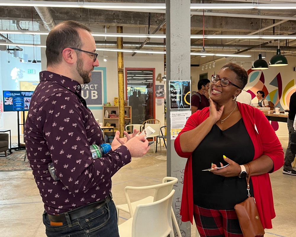 Tywanna Taylor and another person talking to each other in an office space.