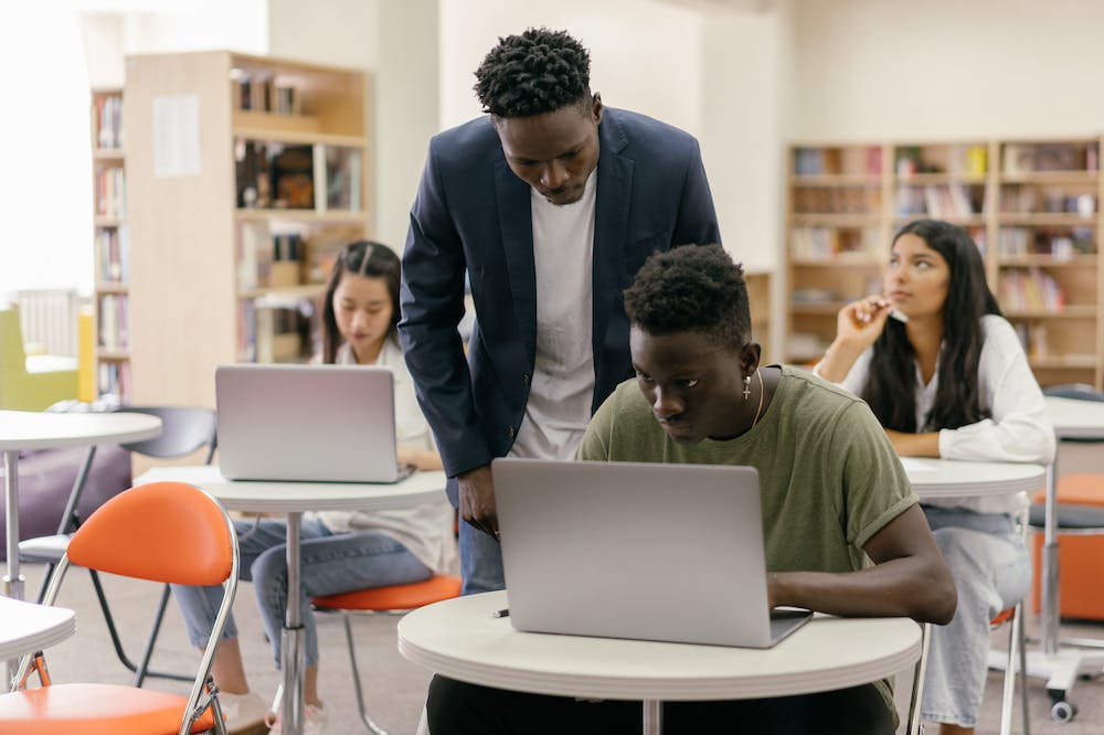 A group of students working on laptops in a library.