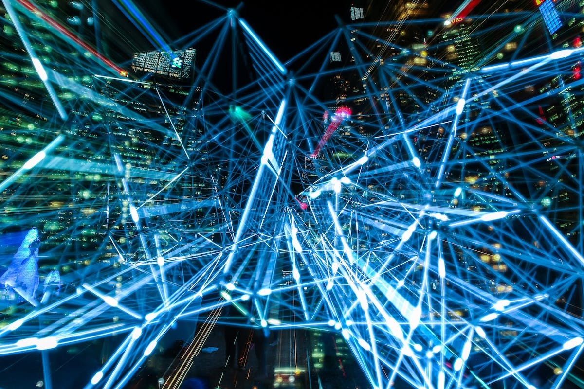 An abstract, blue-tinged, technical image of a city at night.