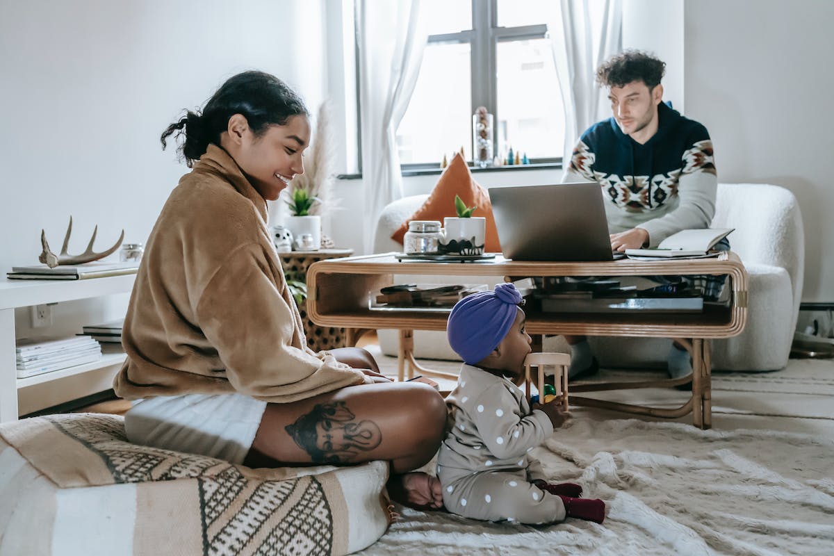 A family with a young child playing in the living room.