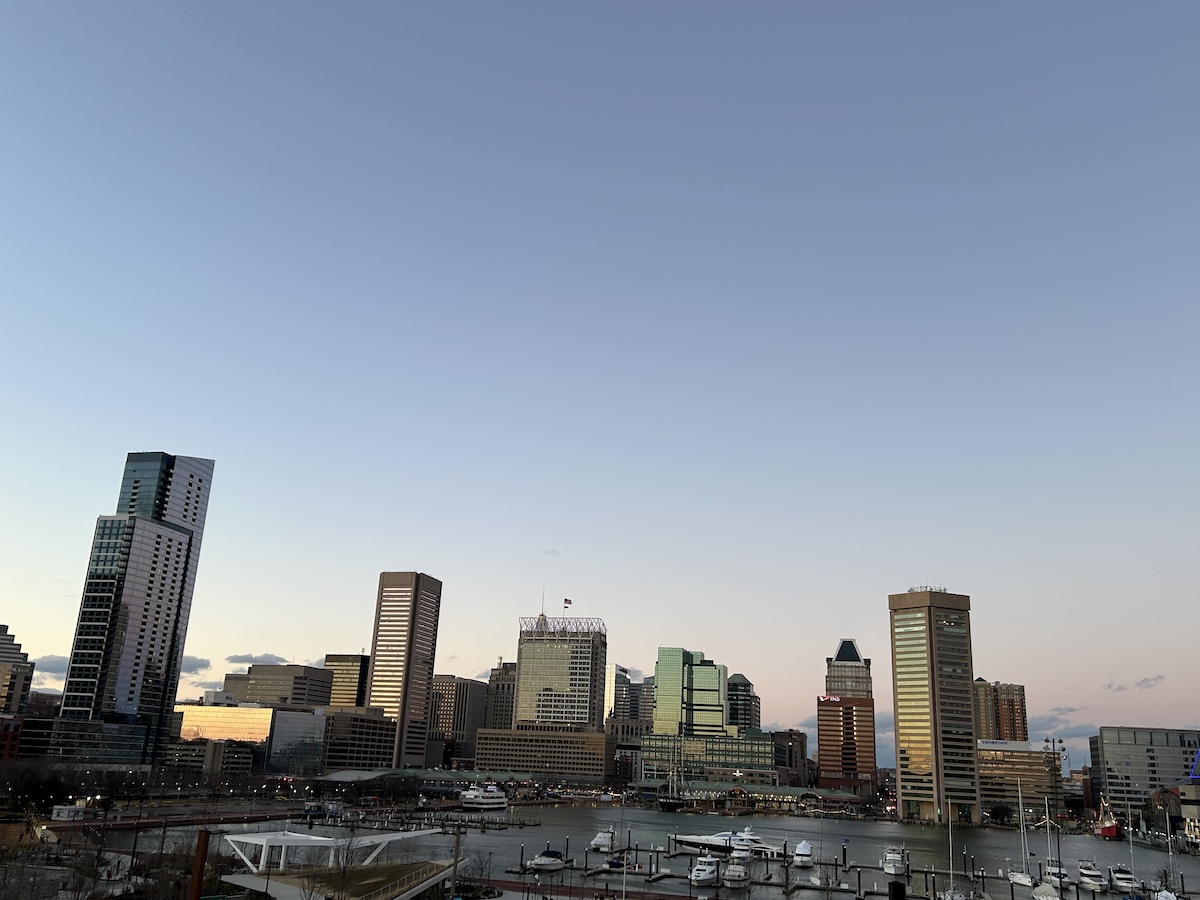Baltimore skyline against blue and orange sky.