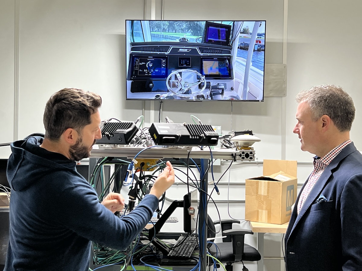 Two men standing in front of a screen in a room.