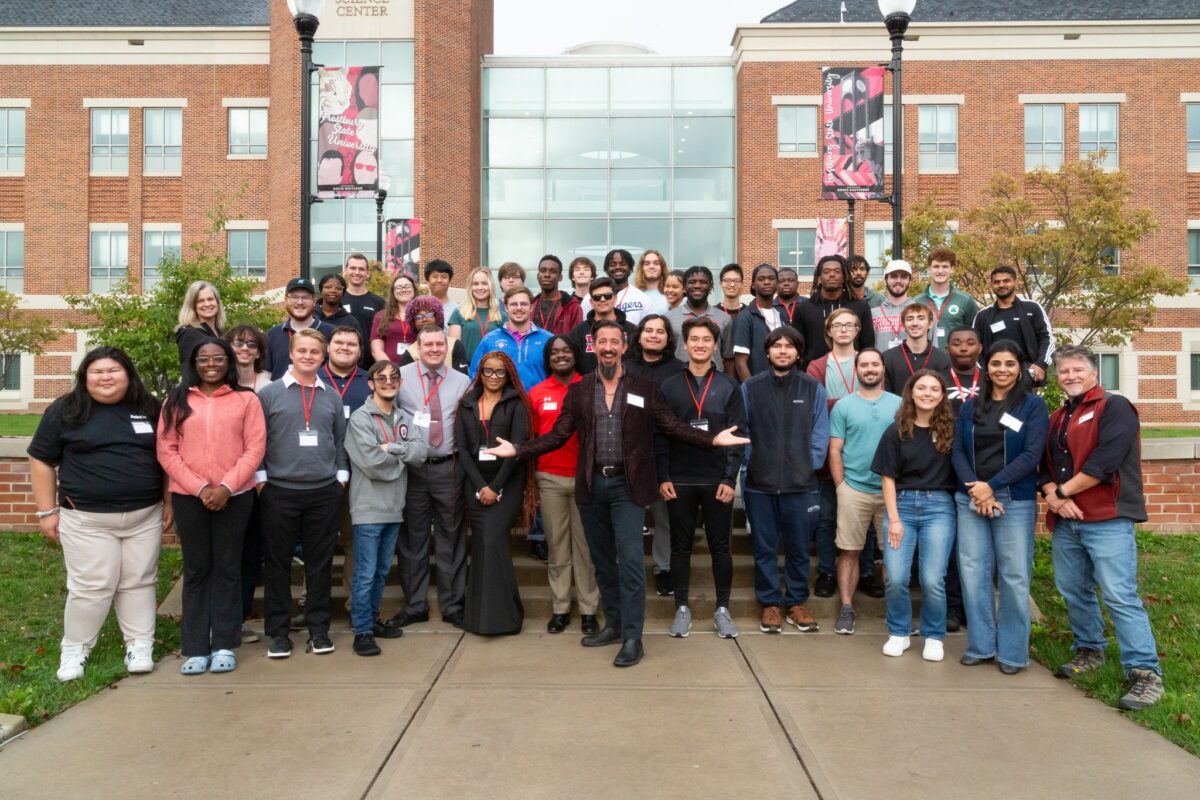 A group of people posing in front of a building.