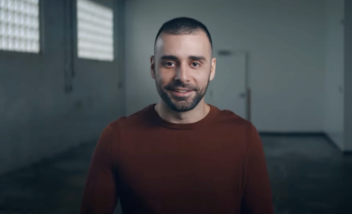 A man smiling in an empty room.