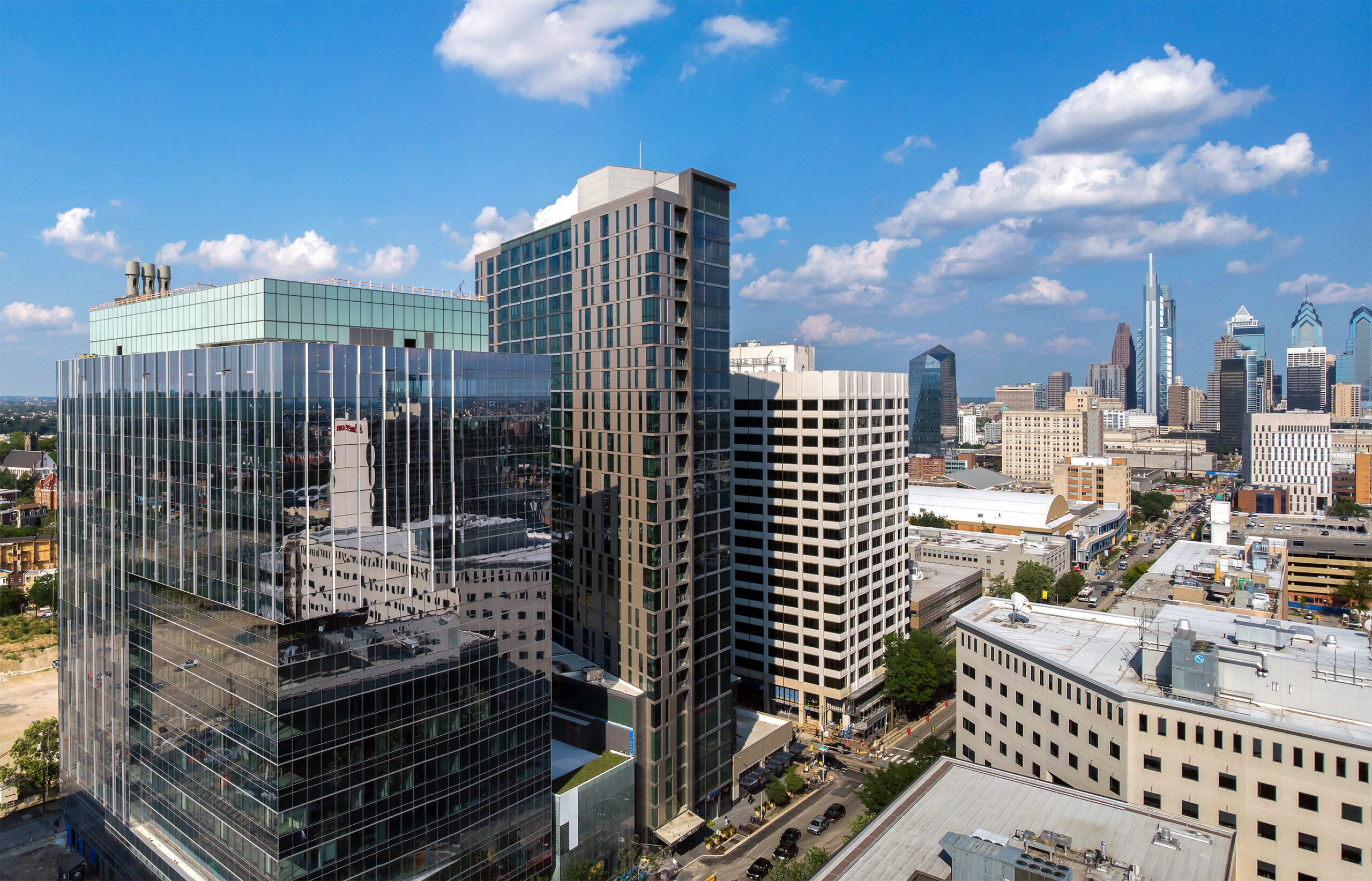 Aerial view of modern skyscrapers in a bustling cityscape with clear skies.