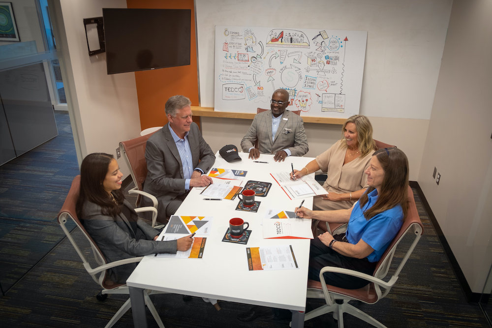 A group of people sitting around a table in a conference room.