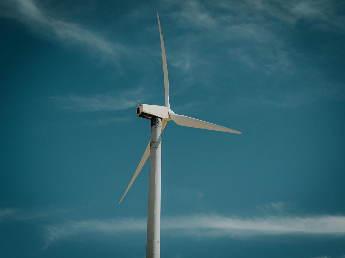 White and grey windmill in front of dark blue sky