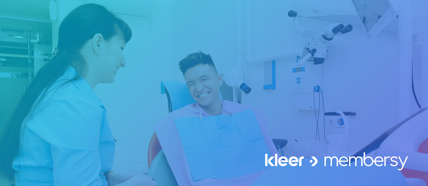 A male patient smiling at a female dentist in an exam room, overlaid with the logos "kleer" and "membersy.
