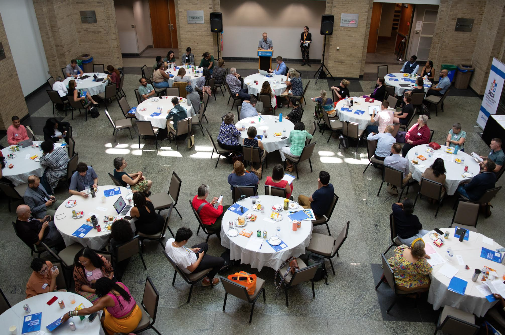 Crowds at white circular tables.