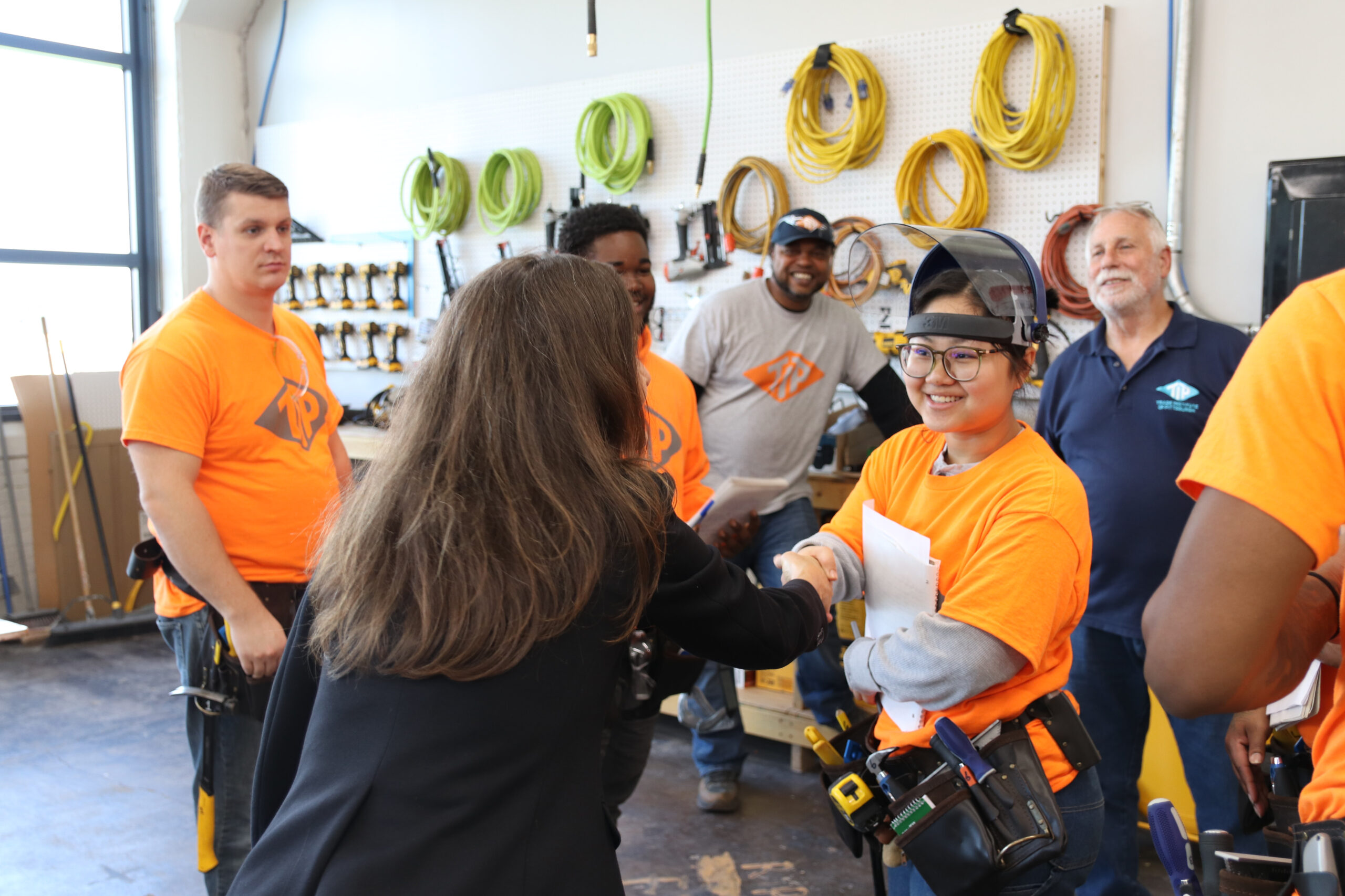 LABOR AND INDUSTRY SECRETARY NANCY WALKER with students in orange shirts