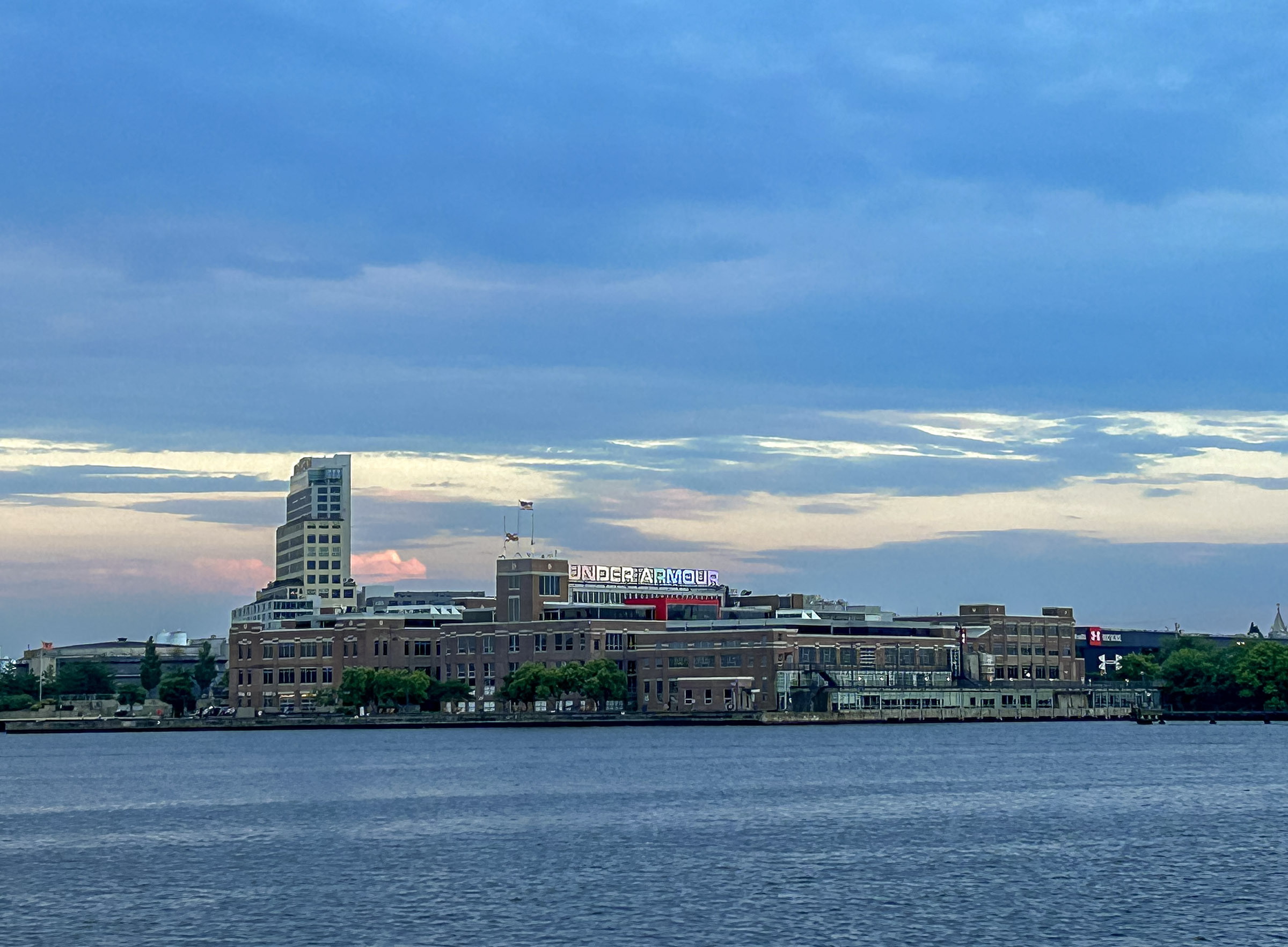 Building across blue water set against blue and pink setting sky.