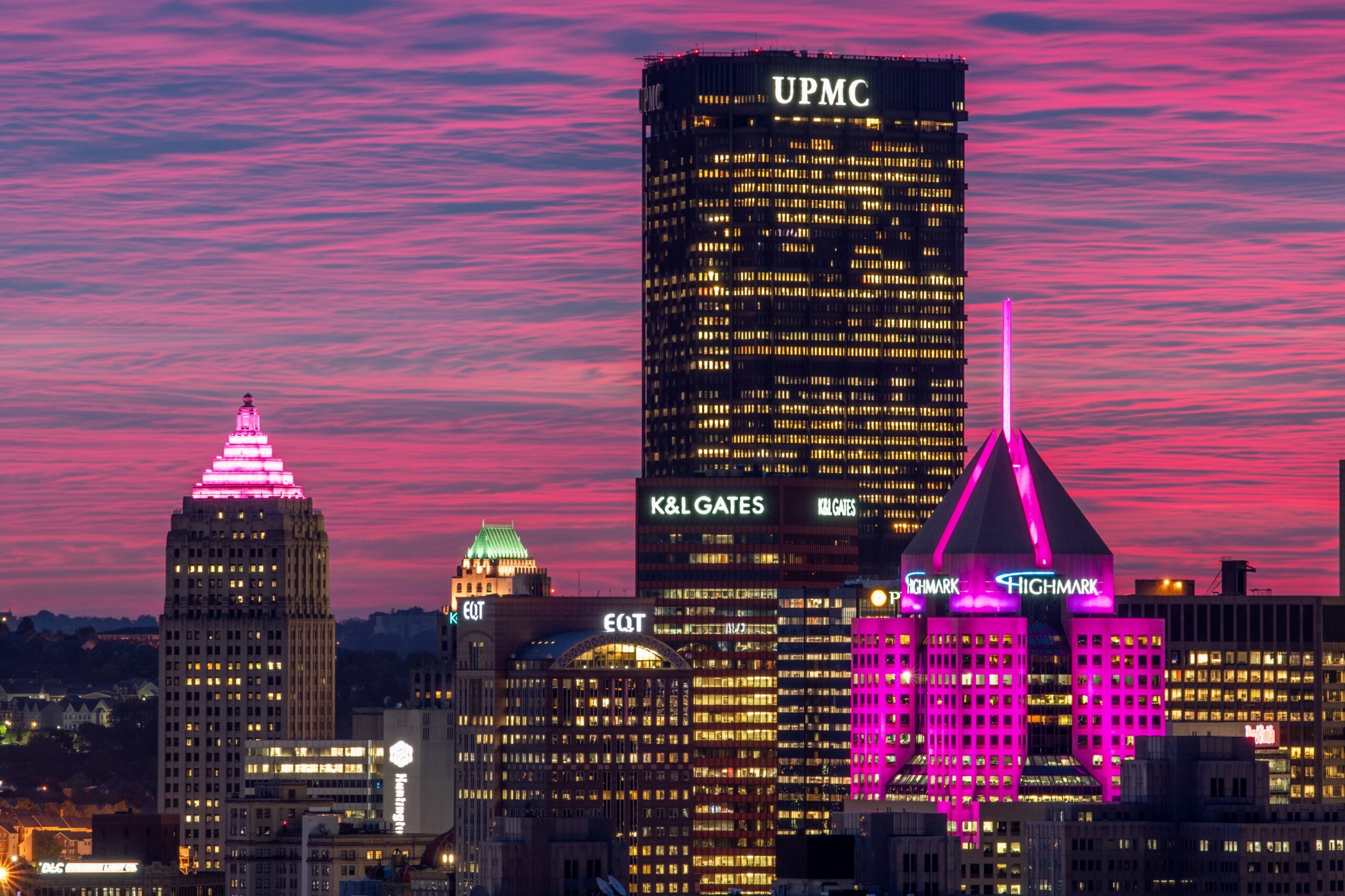 Skyline of downtown Pittsburgh at sunset, creating a purple sky.