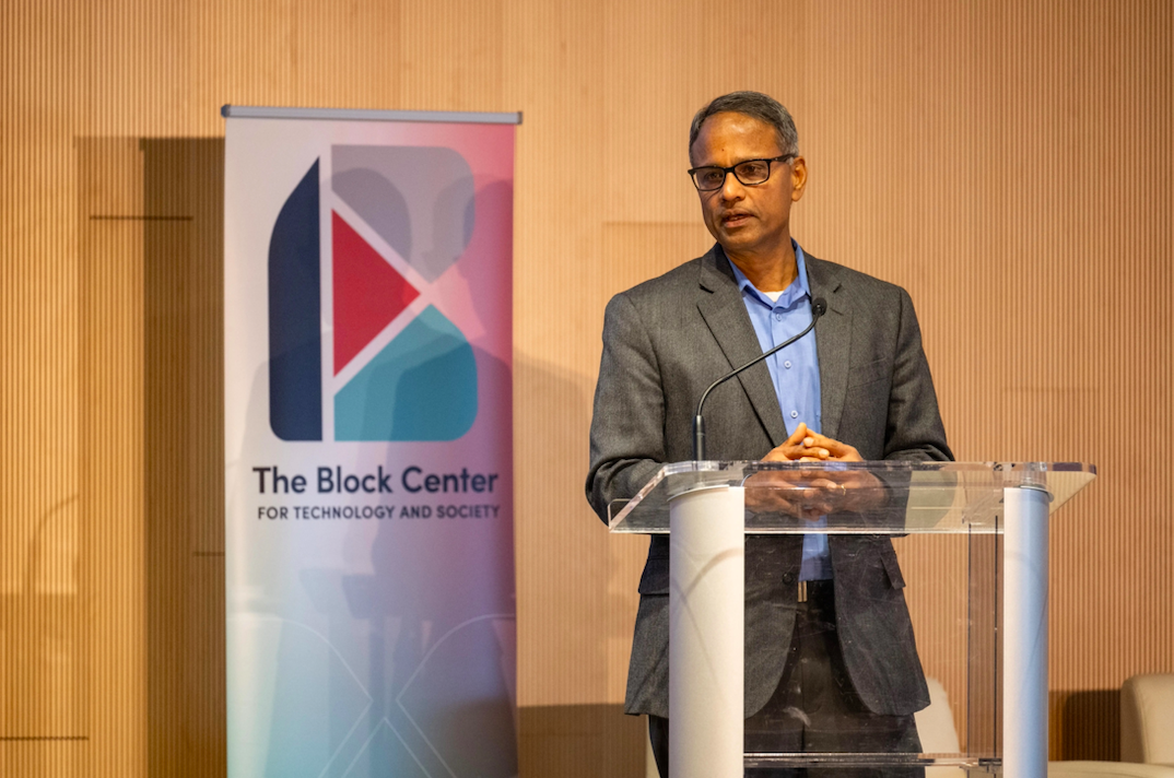 Ramayya Krishnan, Carnegie Mellon University's Block Center for Technology and Society faculty director stands at a podium in front of a sign for the center.