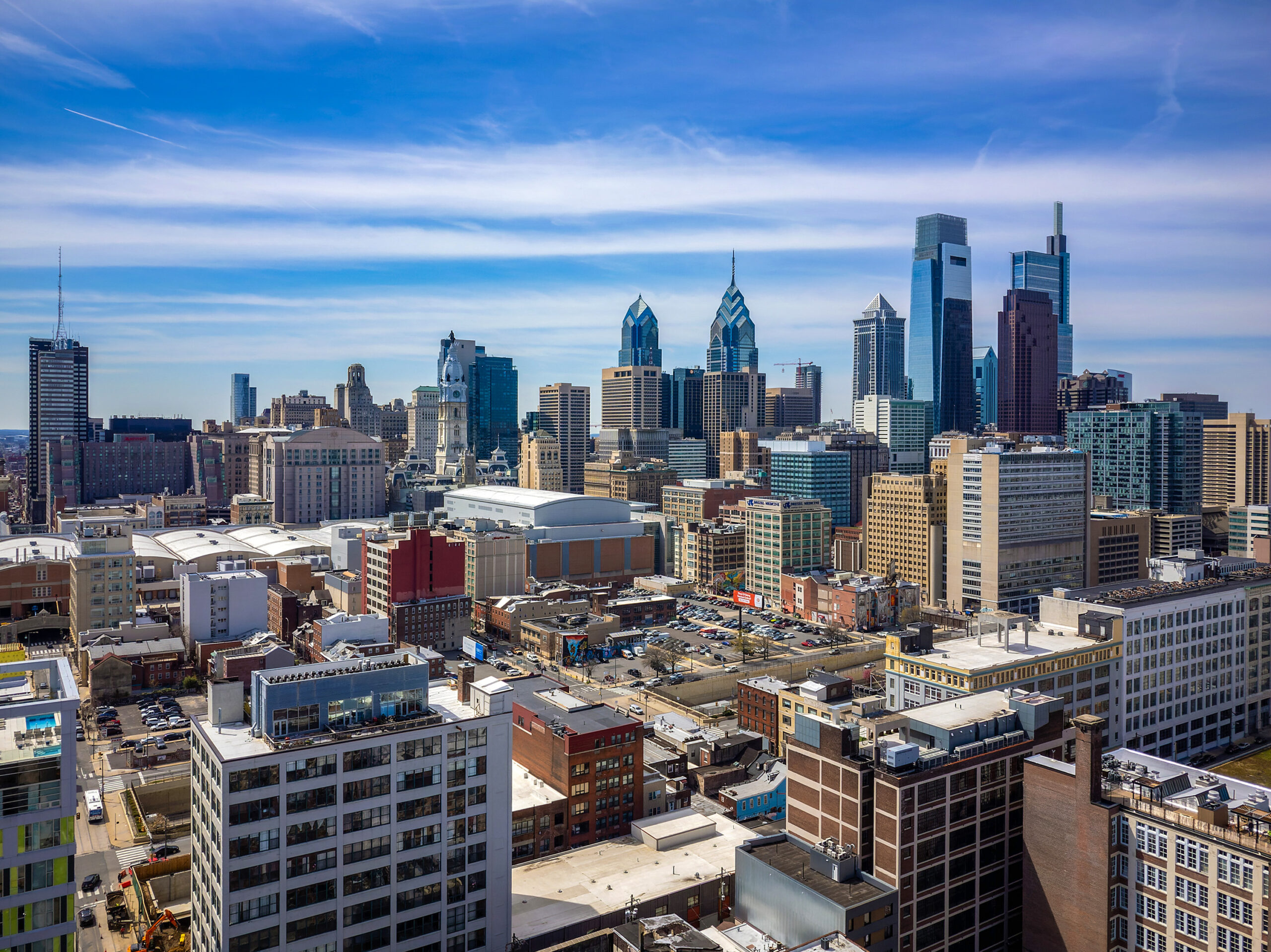 Aerial view of a city skyline with modern skyscrapers and varied architecture under a clear sky.