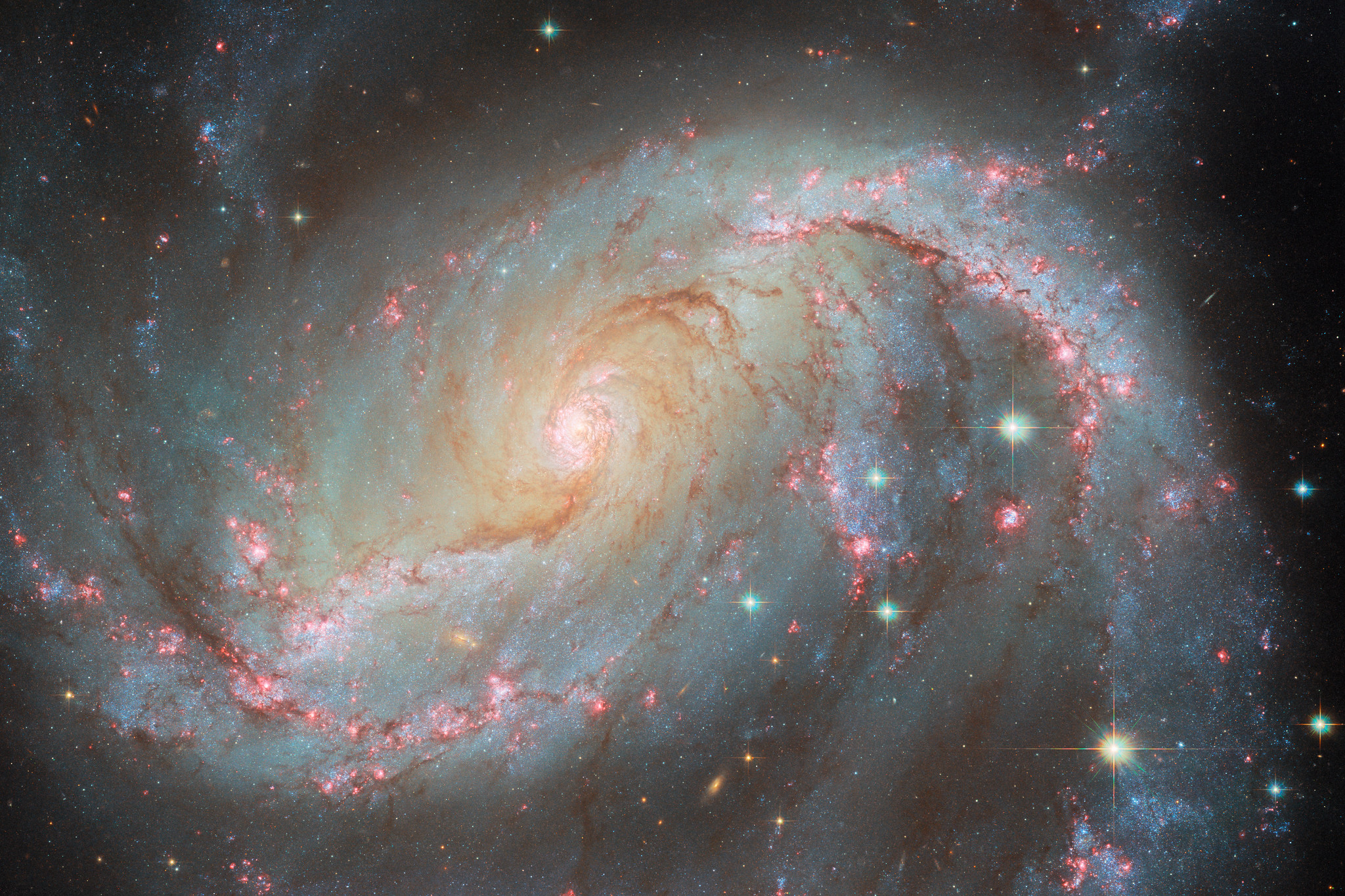 A galaxy with pink webs and swirling yellow and white light with multicolored stars.