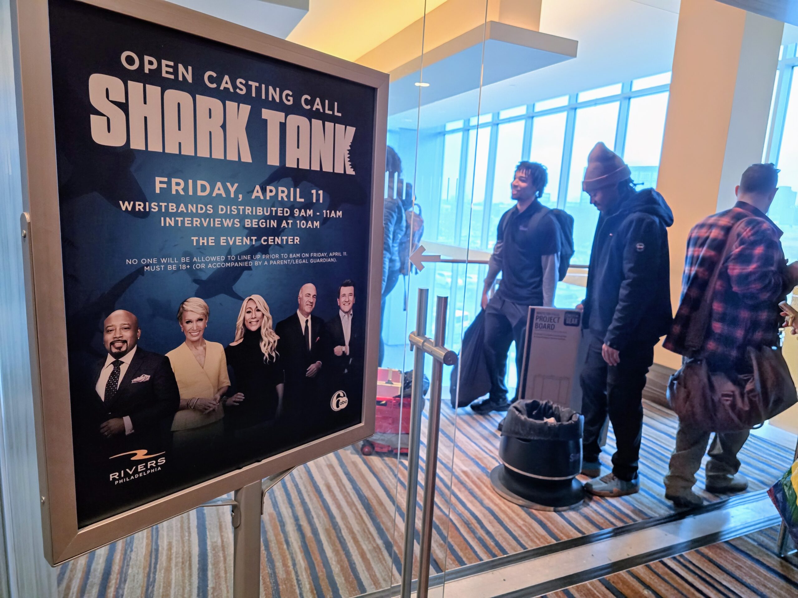 People waiting in line near a Shark Tank sign