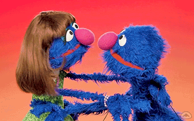Animated gif from Sesame Street of Grover hugging his mother.