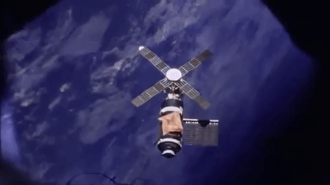 Animated gif of the Skylab space station floating above Earth.
