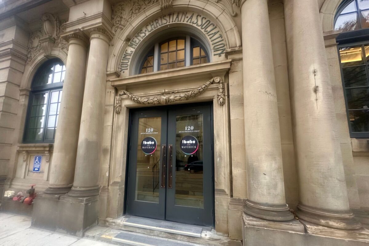 Double doors at the entrance of a stone building labeled "Young Men's Christian Association".