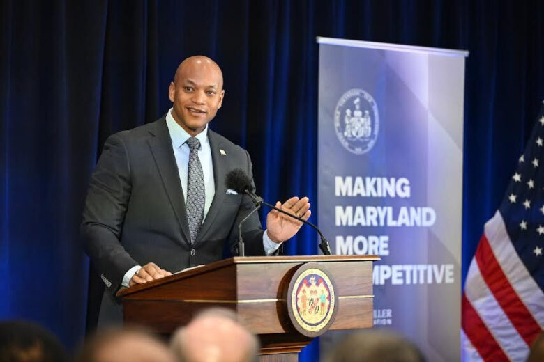 Gov. Wes Moore stands at a podium in front of a sign that says "Making Maryland More Competitive"