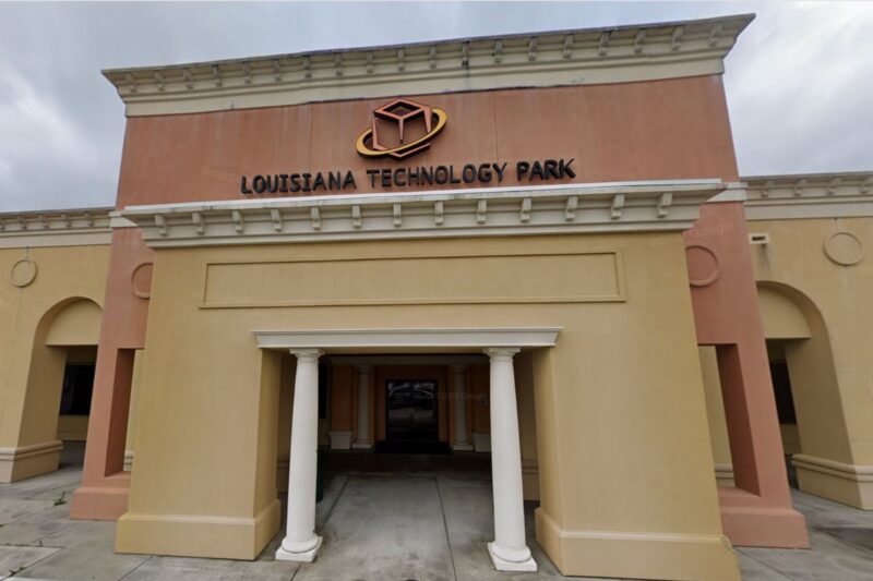 A building with columns at the entrance displays a sign reading "Louisiana Technology Park" above the doorway.