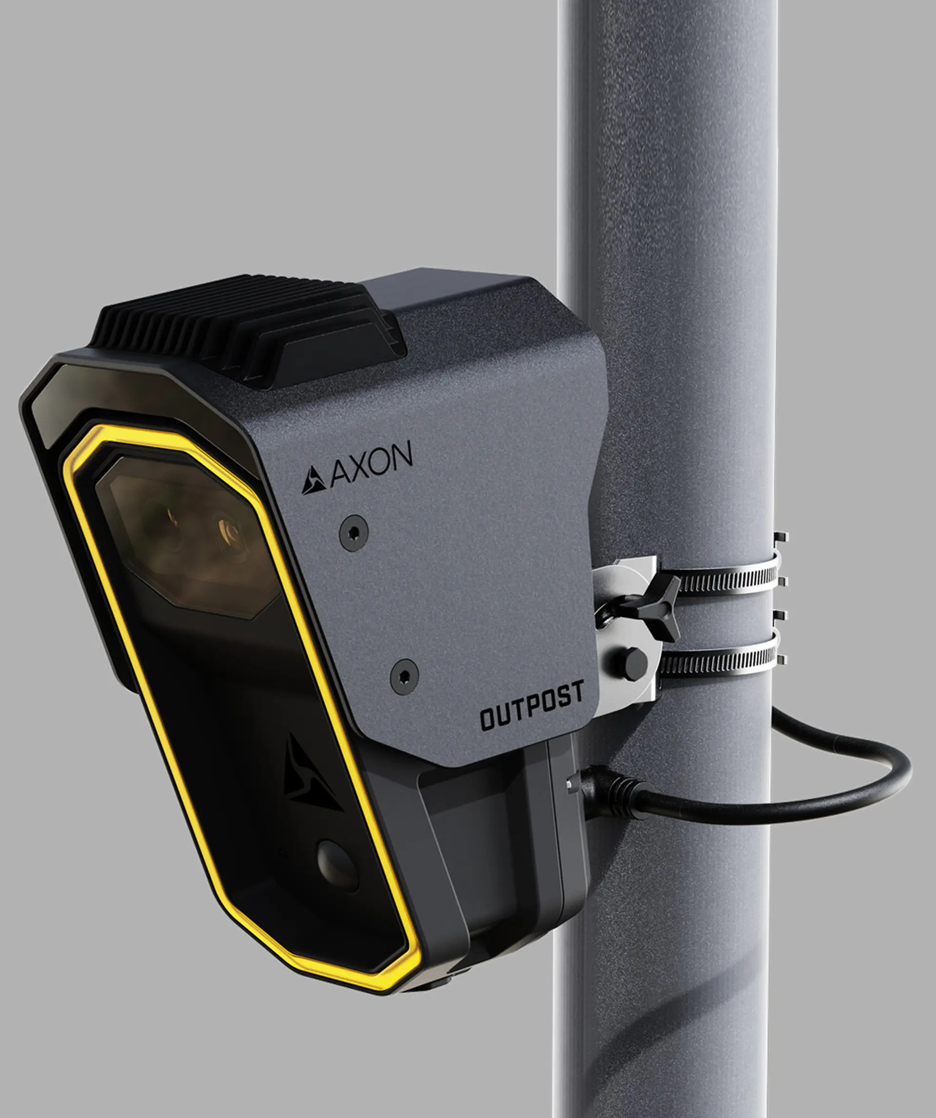 A black Axon Outpost security camera is mounted on a gray metal pole with metal clamps, featuring a yellow trim and connected by a black cable.