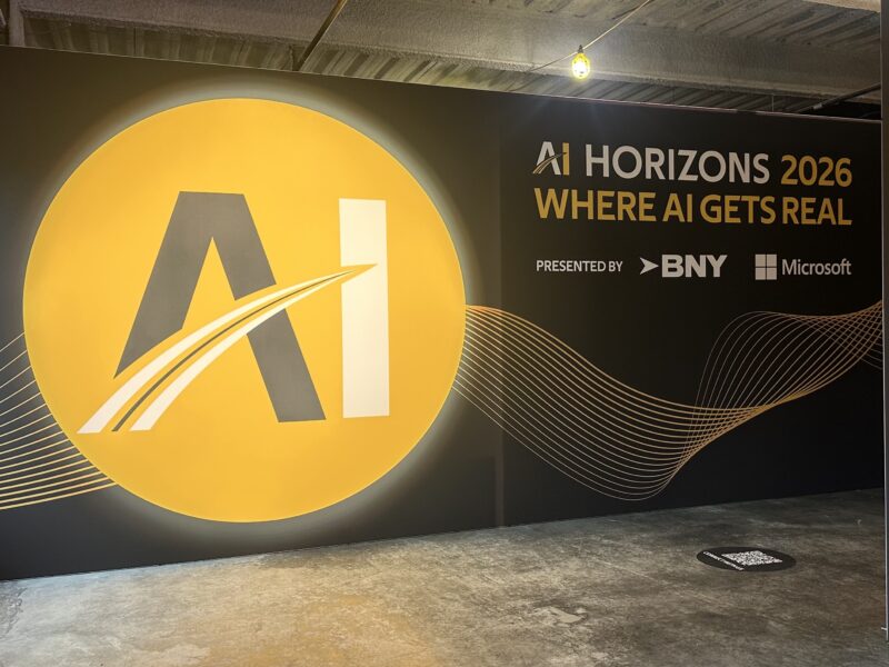 Sign for the AI Horizons 2026 conference, presented by BNY and Microsoft, featuring a large yellow circular logo with “AI” text.