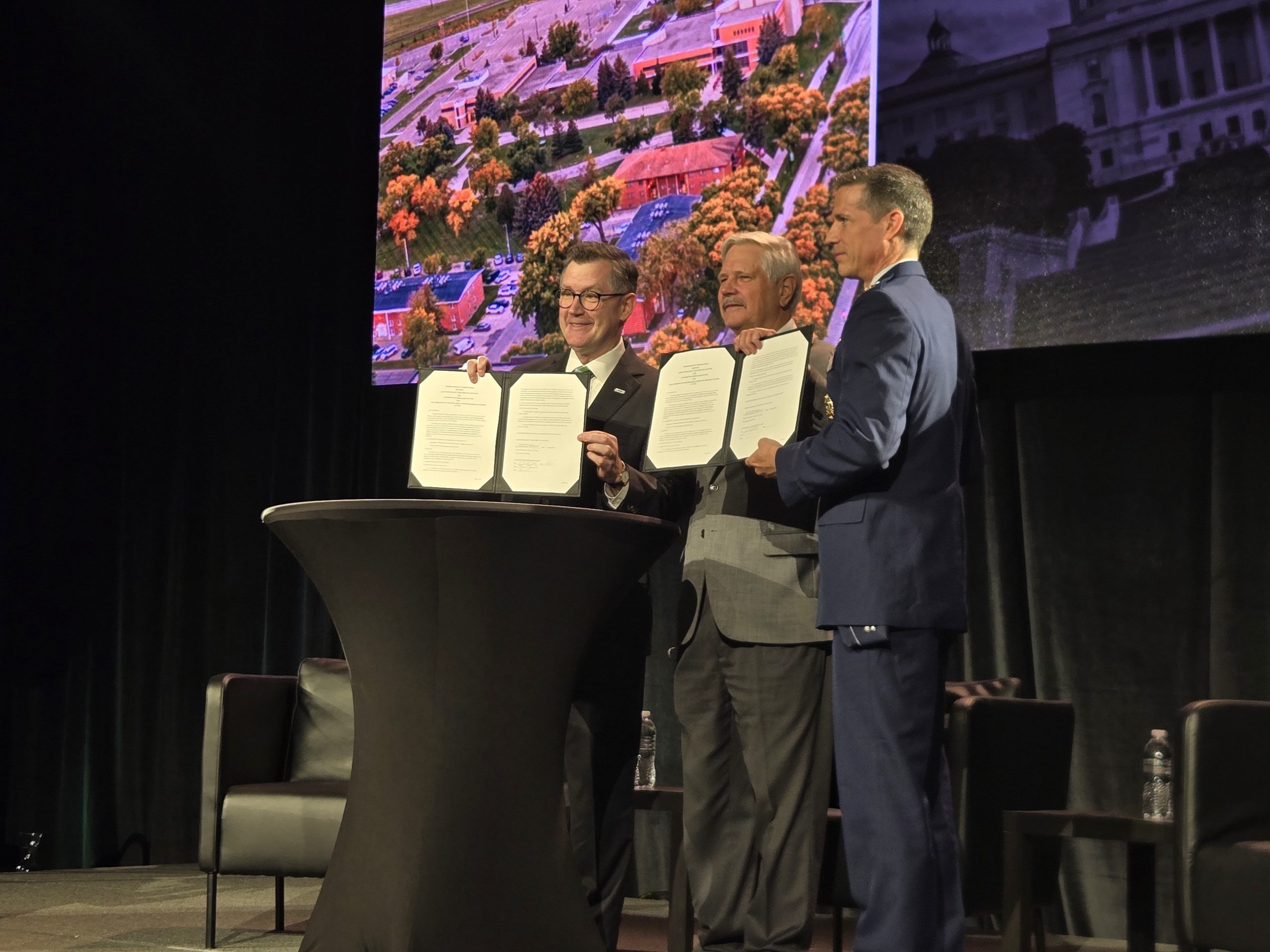 UND President Andrew Armacost, US Senator John Hoeven, and US Air Force Col. Jason Idleman standing on stage at the 2026 UAS Summit & Expo.